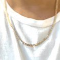 Load image into Gallery viewer, Close-up of a person wearing a 14K gold-filled Figaro chain necklace over a white shirt.