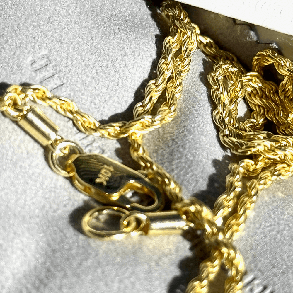 Close-up of a 10K solid yellow gold diamond-cut rope chain necklace with a secure clasp.