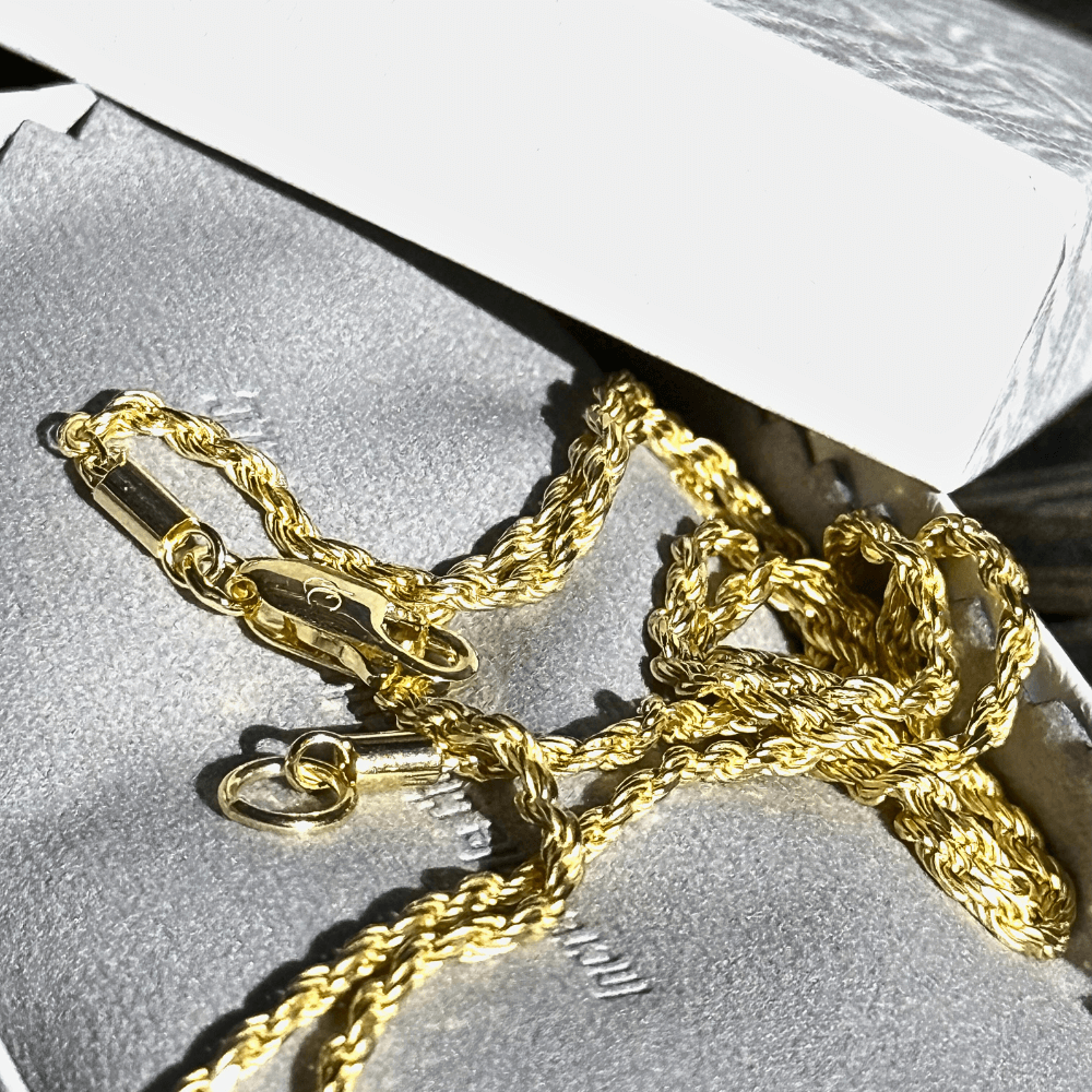 10K solid yellow gold diamond-cut rope chain necklace with clasp, resting in a jewelry box.