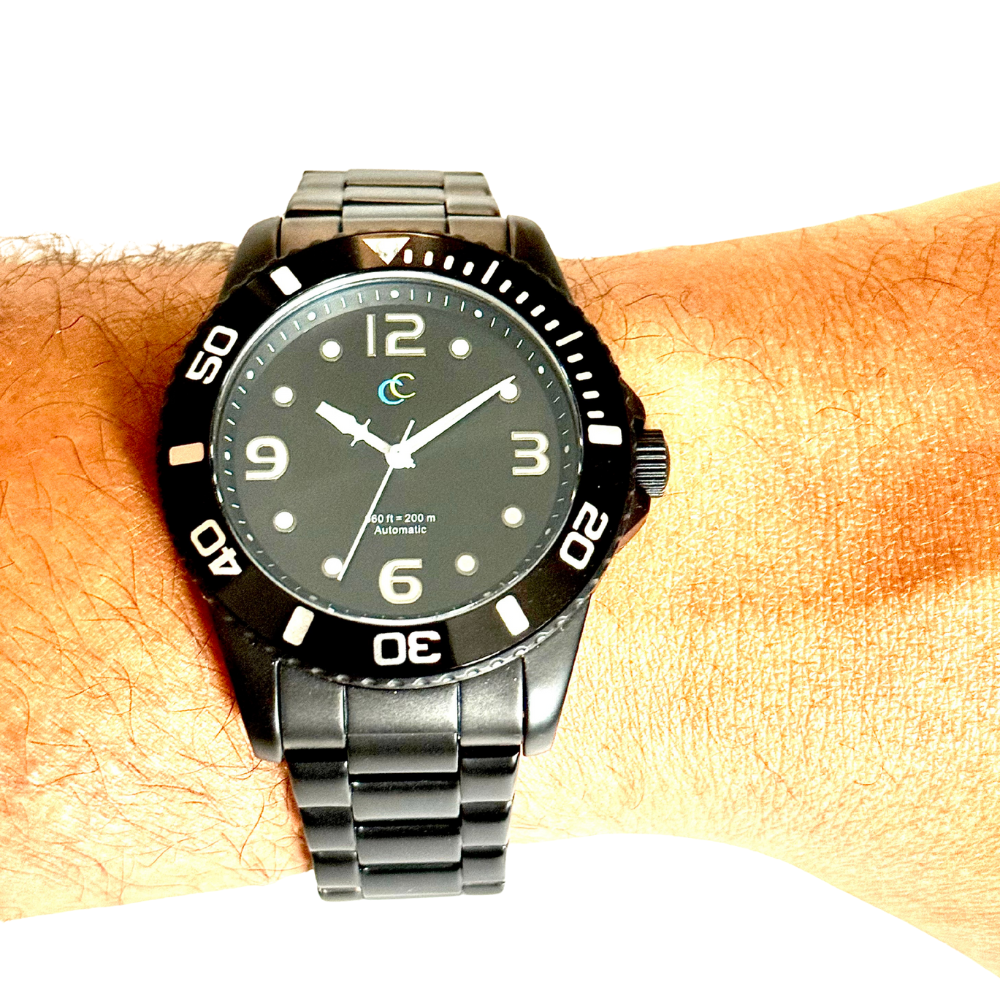 Black watch with a black face on a wrist against a white background