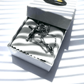 Load image into Gallery viewer, 14k white gold crucifix necklace resting in elegant gift box with soft fabric lining and striped shadows.
