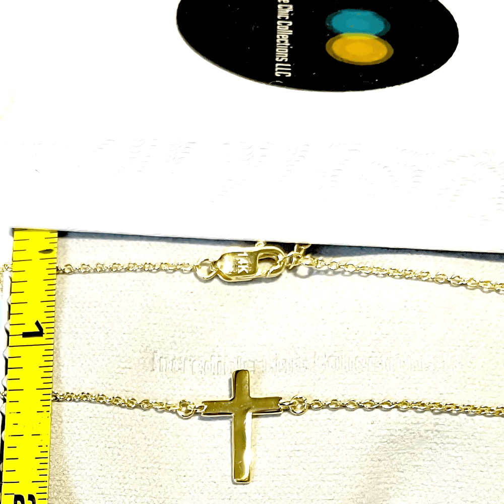 14k gold cross necklace displayed with measuring tape, perfect for layering and a thoughtful gift for her.