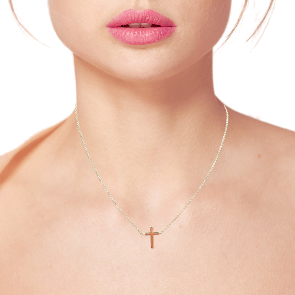 Model wearing a dainty 14k gold cross necklace, showcasing its elegance and perfect for layering or everyday wear.