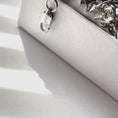 Load and play video in Gallery viewer, Close-up of a white embossed jewelry box with a silver clasp, ideal for storing necklaces and accessories.
