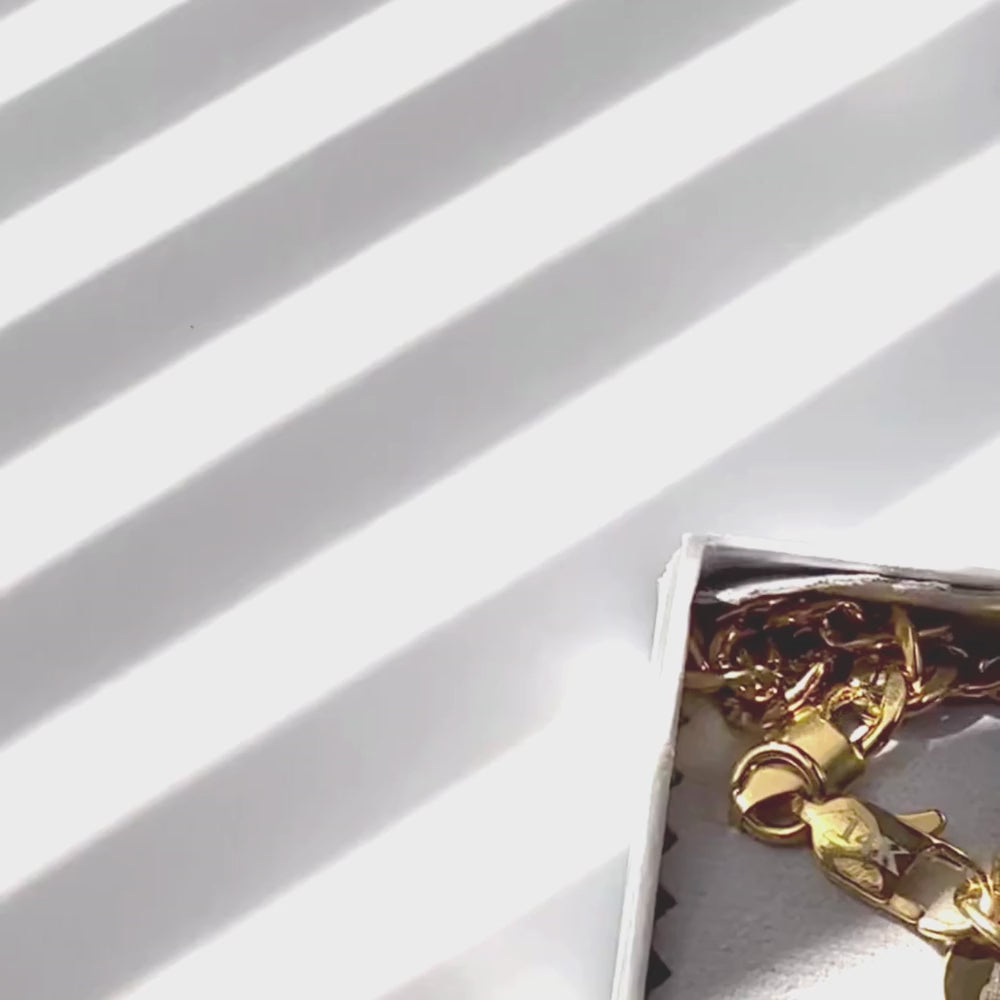 14k gold-filled Figaro chain necklace in a box with light and shadow patterns.