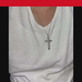 Load and play video in Gallery viewer, Person wearing a silver cross pendant necklace on a white t-shirt, showcasing a stylish accessory.
